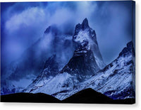 a mountain covered in snow under a cloudy sky