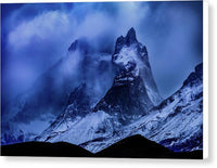 a mountain covered in snow under a cloudy sky