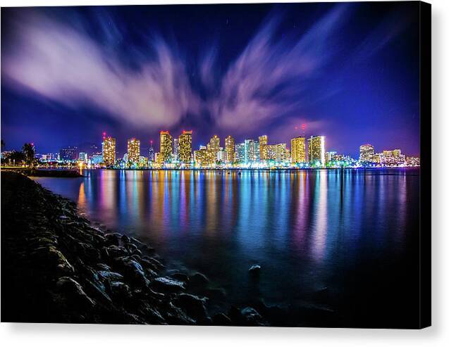 a city skyline at night with clouds in the sky